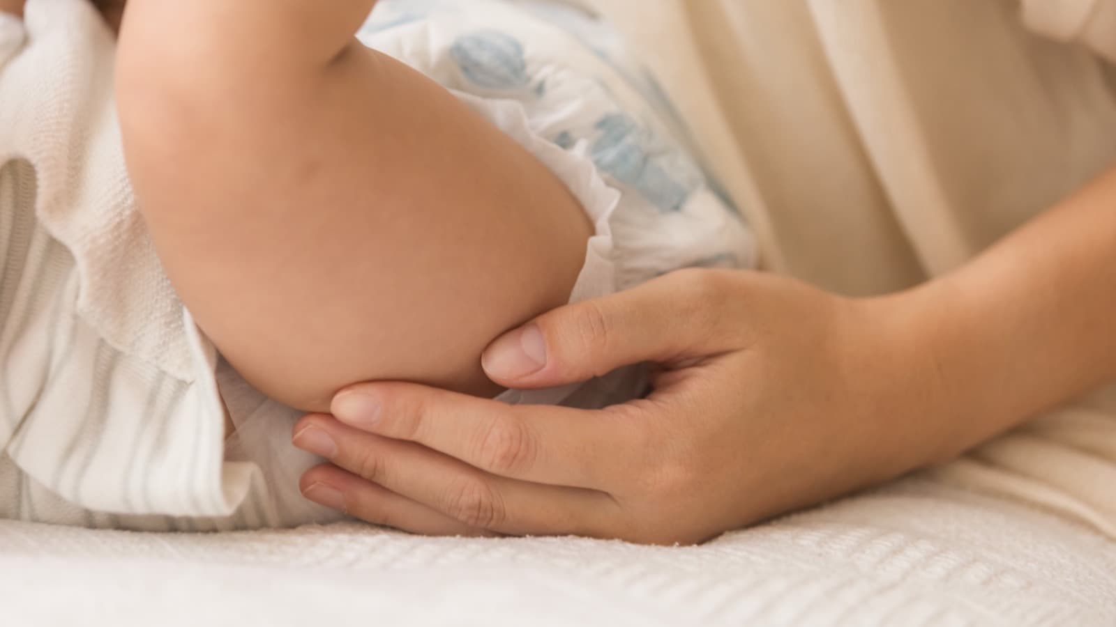 A parent checking the fit of a baby's Little Rei diaper
