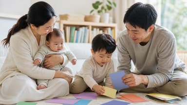 Two parents sitting on the floor with a baby on one lap and a toddler sorting coloured cards between them