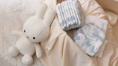 Folded Little Rei diapers beside a soft toy, ready to pack
