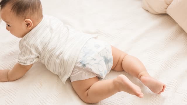 A baby on its tummy wearing a Little Rei tape diaper