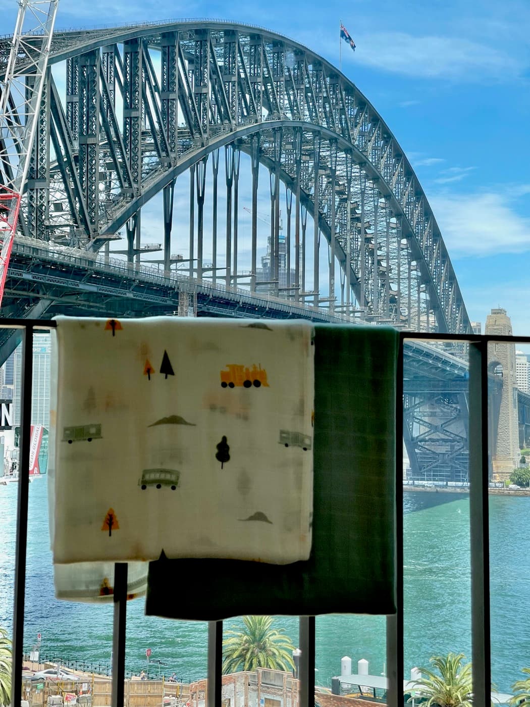 Bamboo muslins drying on a balcony rail under full sun by the harbour