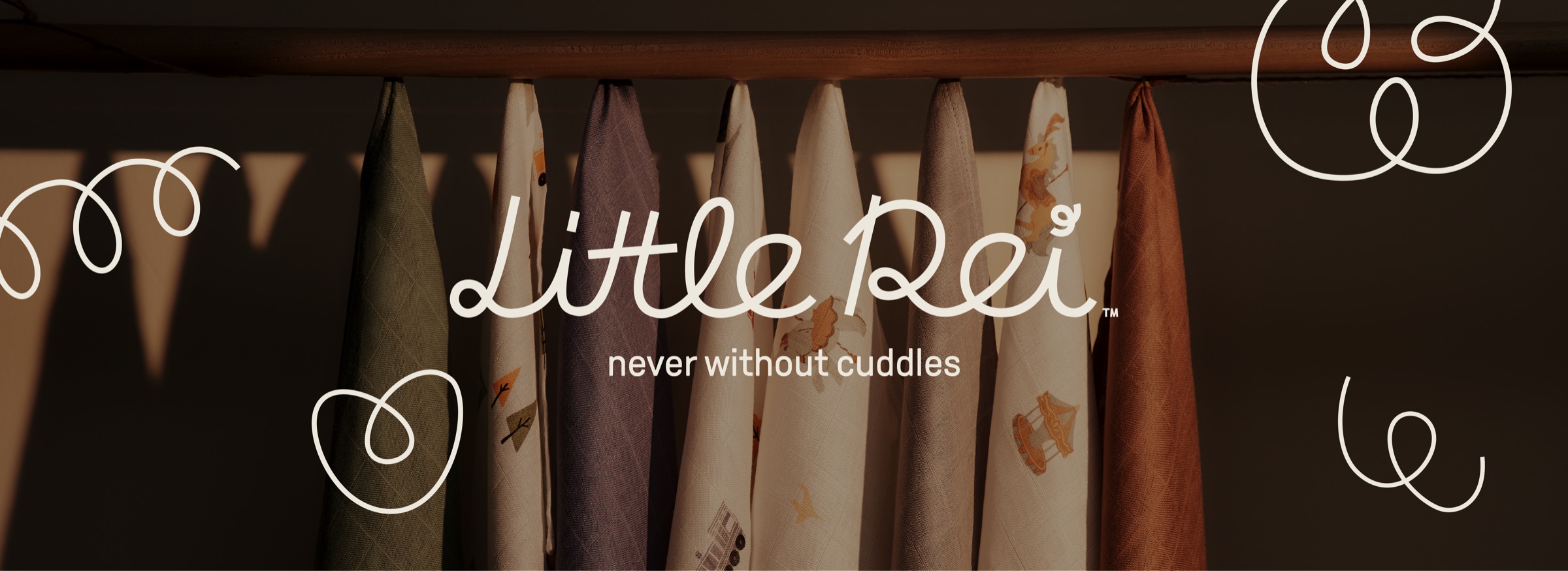Little Rei — never without cuddles. Bamboo swaddles hanging in evening light.