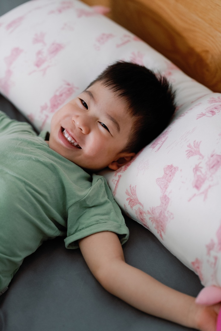 Toddler resting on a Little Rei Rustic Pink pillow